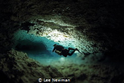 A diver in a passage known as "River Run", in the freshwa... by Lee Newman 